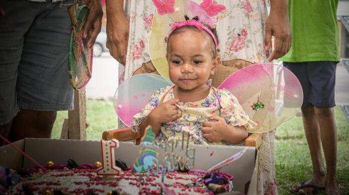 Birthday girl smiling beside her cake
