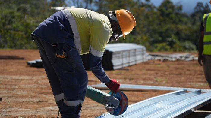 Worker cutting steel with an angle grinder