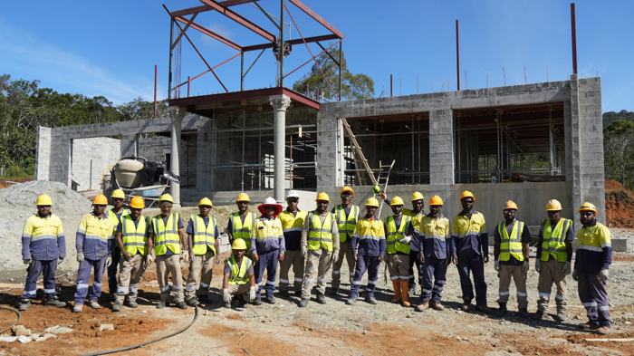 Construction crew lined up in front of a building site
