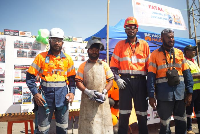 Workers in high-visibility gear at a safety expo stand