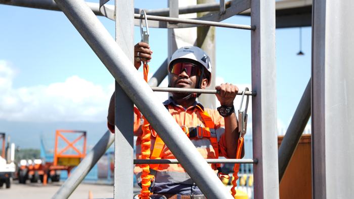 Worker climbing a ladder in a safety harness